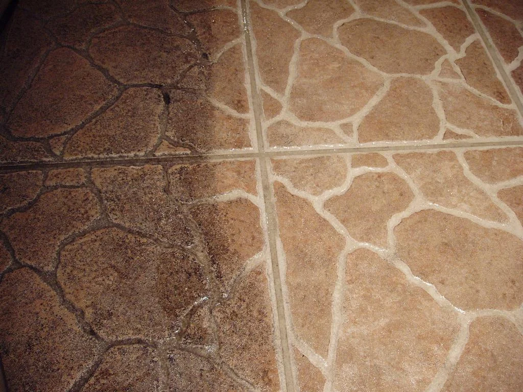 Tile floor with a cleaned section next to an uncleaned section.